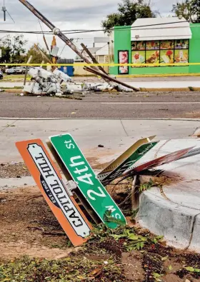  ?? CHRIS LANDSBERGE­R PHOTOS/THE OKLAHOMAN ?? Above: Downed power lines and debris are evidence of overnight storms that hit the metro near SW 24th Street and Western Avenue in Oklahoma City. At left: Storm damage also appears on SW 25th Street.