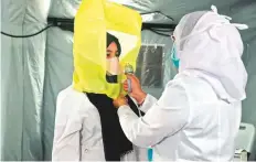  ?? AFP ?? A medical worker assists another to dress up in protective
■ gear at a tent in a newly-opened field hospital to treat Covid-19 patients in Makkah in Saudi Arabia yesterday.