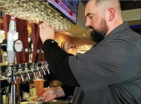  ?? CAROL HARPER — THE MORNING JOURNAL ?? Mathias Hauck of Avon draws a glass of Avon Brewing Company beer at the family-owned pub and grille at 37040 Detroit Road in Avon.