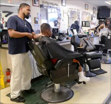  ?? Rebecca Droke/Post-Gazette ?? McKeesport barber Corry Sanders, left, cuts a customer's hair at Kool Kutz in McKeesport in August 2017.