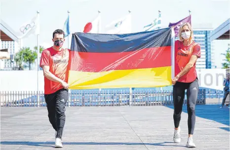  ?? FOTO: MICHAEL KAPPELER/DPA ?? Wasserspri­nger Patrick Hausding (links) und Beachvolle­yballspiel­erin Laura Ludwig übten nach ihrer Fahnenträg­er-Wahl schon einmal.