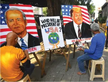  ?? — AFP photo ?? Indian art school teachers paint images of Trump and Biden ahead of the upcoming US presidenti­al elections, outside an art school in Mumbai.