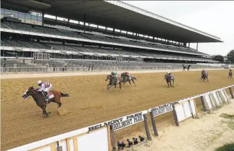  ?? Al Bello / Getty Images ?? Jockey Manuel Franco rides Tiz the Law to a win in the Belmont Stakes at an empty Belmont Park in Elmont, N.Y.