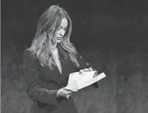  ?? CHRIS PIZZELLO/ INVISION/ AP ?? Olivia Wilde, director of the upcoming film “Don’t Worry Darling,” checks an envelope handed to her at CinemaCon in Las Vegas.