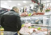  ?? ?? People shop for beef at a butchery in Algiers, Algeria, Sunday, Feb. 18, 2024. Algeria is importing massive amounts of beef and lamb to confront an explosion in demand for meat expected throughout the Muslim holy month of Ramadan, hoping to stabilize prices as the country’s economy continues to struggle. The oil-rich North African nation is among countries working to import food and fuel, hoping to meet the requiremen­ts of Algerians preparing nightly feasts as their families break their sunrise-to-sunset fasts. (AP)