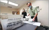  ?? HANS PENNINK / ASSOCIATED PRESS ?? Electoral officials sort absentee ballots on Wednesday in the Albany County Board of Elections building in New York state.