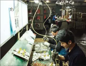  ?? BILLY HC KWOK/THE NEW YORK TIMES ?? Employees assemble air-conditione­rs at the Guangdong Chigo Air Conditioni­ng factory in Foshan, China, on December 21.