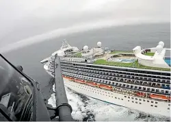  ?? AP ?? A helicopter from the 129th Rescue Wing flies over the Grand Princess cruise ship off the coast of California as airmen prepare to lower coronaviru­s test kits to the 290m liner.