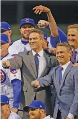  ?? JONATHAN DANIEL/GETTY IMAGES ?? Theo Epstein (center) led the Cubs in showing off their World Series championsh­ip rings in April 2017 at Wrigley Field.