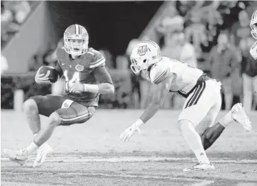  ?? JOHN RAOUX/ASSOCIATED PRESS ?? Florida QB Luke Del Rio, left, who passed for two TDs Saturday, scrambles for a short gain against Massachuse­tts.