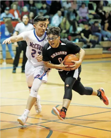  ?? LUIS SÁNCHEZ SATURNO/THE NEW MEXICAN ?? McCurdy’s Ubaldo Barela, left, covers Monte del Sol’s Peter Lujan during the first quarter of Thursday’s District 2-2A game at McCurdy. The Bobcats won, 69-59.