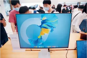  ??  ?? 在上海南京路步行街上，华为旗舰店提供鸿蒙（Harmonyos）智能终端操作系统的多­平台（手机、电脑、电视、平板）应用体验，吸引了众多消费者尝鲜。