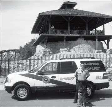  ?? LOANED PHOTO ?? DEPUTY WILLIAM RICE STANDS NEXT TO A POLICE VEHICLE at the Yuma Territoria­l Prison with K-9 Paris, a male German Shepherd who worked with the Yuma County Sheriff’s Office for six years. Paris died on Thursday. Phoenix skating rink’s roof partially...