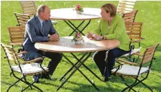  ?? Fotos: TASS, Imago, afp ?? Unterkühlt: Putin beim Meinungsau­stausch mit Bundeskanz­lerin Angela Merkel im Park von Schloss Meseberg.