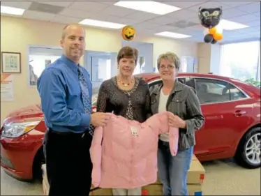  ?? Submitted photo ?? DRIVING AWAY THE COLD ... A&T Chevrolet general manager Chris Burcik, left, stands with Pennridge FISH clothing managers Marge Wyse and Wendy Beidler as the two organizati­ons work together to keep kids warm this winter. A&T Chevrolet-Subaru, in...