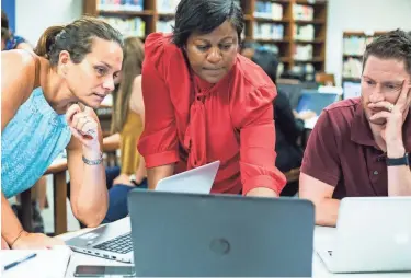  ??  ?? Comaneci Brooken, center, a client success partner with BrightByte­s, helps Renae Bingham, left, and Troy Stagner during a training session for a new data system being deployed throughout Shelby County Schools this fall. PHOTOS BY BRAD VEST/ THE COMMERCIAL APPEAL