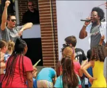  ?? MICHILEA PATTERSON — DIGITAL FIRST MEDIA ?? Aaron Christ, left, and David Charles, right, of Fresh Start Fitness get families hyped up while shooting a music video about eating healthy during a celebratio­n for families at the Pottstown High School on Saturday.