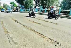  ?? AHMAD KHUSAINI/JAWA POS ?? JALAN TAK RATA: Muncul cekungan di jembatan di Jalan Stasiun Kota. Kondisi ini bisa membahayak­an pelintas.