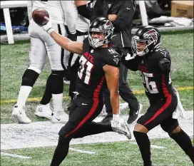  ?? CURTIS COMPTON/CURTIS.COMPTON@AJC.COM ?? Falcons DT Jacob Tuioti-mariner (left) celebrates his sack of Raiders QB Derek Carr and his fumble recovery Sunday with Isaiah Oliver.