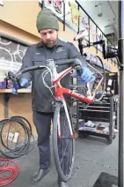  ?? MICHAEL SEARS / MILWAUKEE JOURNAL SENTINEL ?? Service manager Mike Teff works on getting a customer's bike ready for the season at Wheel and Sprocket bike shop in Fox Point. The shop has been busy with people buying bikes and getting them repaired or tuned up for the season.