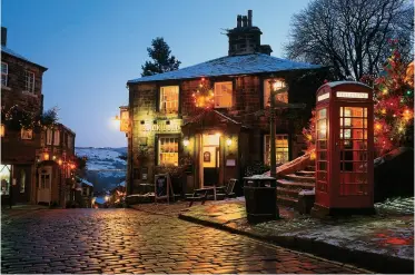  ?? ROY HAMPSON ?? Christmas lights give a welcoming glow to the famous town of Haworth in Yorkshire — the childhood home of the Brontë family. See poem this page.