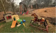  ??  ?? Toys stand untouched near a home destroyed by the wildfires west of Redding, California. Photo: Bob Strong