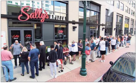  ?? Christian Abraham / Hearst Connecticu­t Media ?? A crowd lines up Thursday on Summer Street in Stamford waiting to enter Sally’s Apizza. After months of constructi­on, design and waiting, the pristine glass doors opened to Sally’s first location outside of New Haven.