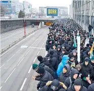  ??  ?? Das Szenario sieht nicht ungefährli­ch aus. Die Fans des SK Rapid Wien wurden mehrere Meter über der Südosttang­ente von der Polizei eingekesse­lt.