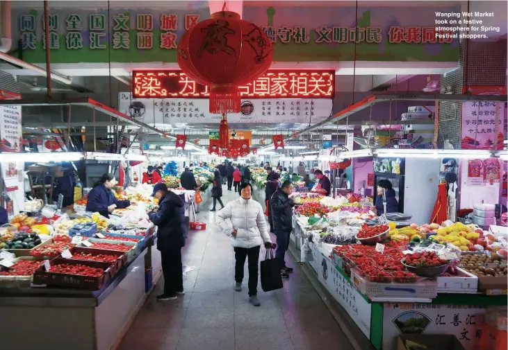  ??  ?? Left: A customer selects plants at Feng’s flower shop. Wanping Wet Market took on a festive atmosphere for Spring Festival shoppers.