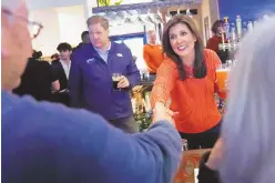  ?? CHARLES KRUPA/STAFF, ASSOCIATED PRESS ?? Republican presidenti­al candidate former UN Ambassador Nikki Haley shakes hands with a patron during a campaign stop at a restaurant, Monday, Jan. 22, 2024, in Concord, N.H. At left is N.H. Gov. Chris Sununu.