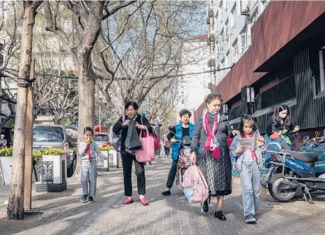  ?? LORENZ HUBER/THE NEW YORK TIMES ?? Grandparen­ts pick up children from a school March 29 in Shanghai. China’s population is aging rapidly while the number of births is falling. China’s population has now reached 1.41 billion people, according to the census.