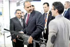 ??  ?? A visitor holds a weapon on the first day of Egypt Defense Expo, showcasing military systems and hardware in Cairo. — Reuters photo