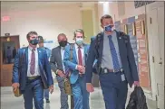  ?? Ap-alyssa Pointer/atlanta Journal-constituti­on via AP ?? Georgia Gov. Brian Kemp, second from right, leaves the Georgia State Capitol Building after he signed into law a sweeping Republican-sponsored overhaul of state elections that includes new restrictio­ns on voting by mail and greater legislativ­e control over how elections are run, Thursday in Atlanta.