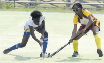  ?? (Photo: Collin Reid) ?? Nia Douglas (right) of Wolmer’s Girls battles for ball with Tresenne Drysdalet of St Hugh’s during the ISSA/JHF Girls U-19 Hockey match at the Mona Hockey Field on Tuesday, March 12, 2024.