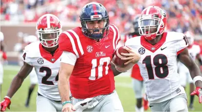  ??  ?? Mississipp­i quarterbac­k Chad Kelly runs past two Georgia defenders on his way to a 41- yard touchdown Saturday. | AP