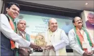  ?? PTI PHOTO ?? Maharashtr­a CM Devendra Fadnavis presents an idol of Lord Ganesha to BJP president Amit Shah as Union minister Venkaiah Naidu looks on during the party’s CMS meeting at Maharashtr­a Sadan in New Delhi on Saturday.