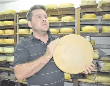 ??  ?? El Ing. Diego Brítez nos muestra la variedad de quesos que produce en las instalacio­nes de la Coop. La Vencedora.
