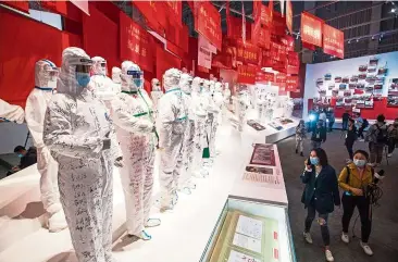  ?? — Xinhua ?? Hello heroes: People visiting an exhibition on China’s fight against the Covid-19 outbreak in Wuhan.