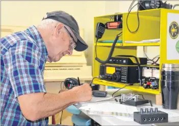  ?? LAWRENCE POWELL ?? Bill Underwood jots down numbers as he seeks contacts during the American Radio Relay Leaque’s annual field day. Underwood is with the Greenwood Amateur Radio Club that was operating out of the community hall in Wilmot June 23.