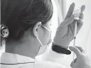  ?? EUGENE HOSHIKO/AP ?? A health worker prepares a dose of the Moderna vaccine on June 30 at Sumida ward of Tokyo.