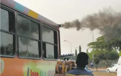  ?? REUTERS ?? Un autobús escupe humo por el escape en una central de autobuses en Abuja, Nigeria
