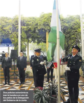  ?? ?? Dos policías autonómico­s izan la bandera en uno de los patios de la Delegación del Gobierno de la Junta.