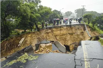  ?? THOKO CHIKONDI/AP ?? Major damage bisects the road connecting the cities of Blantyre and Lilongwe on Tuesday in Malawi following heavy rains caused by Tropical Cyclone Freddy. The unrelentin­g cyclone, which is currently battering southern Africa, has killed more than 200 people in Malawi and Mozambique since it struck the continent for a second time Saturday night.