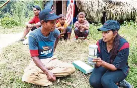  ??  ?? Employees of Veritas explaining to the Bateq people about the solar lights.