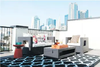  ?? HEATHER HAWKINS/ABBE FENIMORE/THE ASSOCIATED PRESS ?? An outdoor rug in a rooftop sitting area brings the softness of a living room to an outdoor space. Designers say that outdoor furnishing­s have come a long way. Look for rugs, lighting, sofas and more. Also, consider temperatur­e management, including...