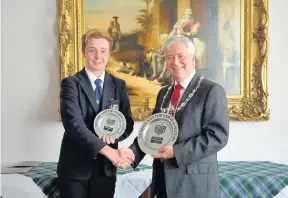  ??  ?? Presentati­on Cameron McCall receives the trophies he won Stateside from Provost Robbins