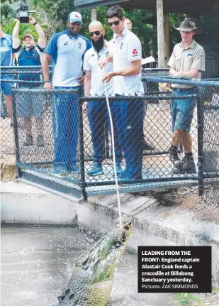  ?? Pictures: ZAK SIMMONDS ?? LEADING FROM THE FRONT: England captain Alastair Cook feeds a crocodile at Billabong Sanctuary yesterday.