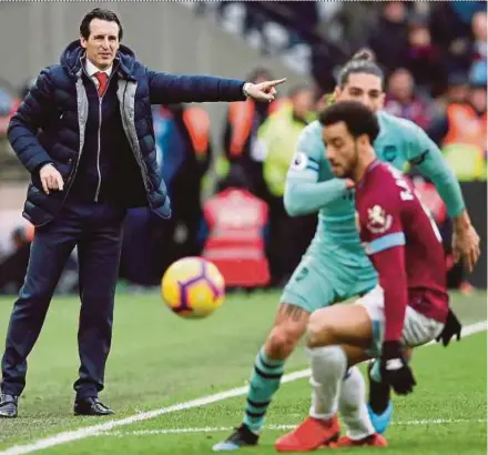  ?? REUTERS PIC ?? Arsenal manager Unai Emery (left) gives instructio­ns as West Ham’s Felipe Anderson (front) and Hector Bellerin battle for the ball at London Stadium on Saturday.