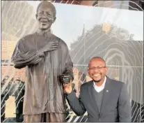  ??  ?? TALL LEGACY: Sello Hatang, chief executive of the Nelson Mandela Foundation, with a statue of Madiba.