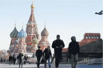  ??  ?? ► Gente camina por la Plaza Roja y el mausoleo del fundador del estado soviético, Vladimir Lenin, y la catedral de San Basilio, en el centro de Moscú.
